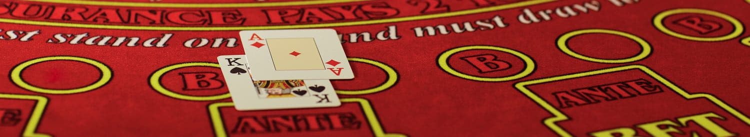 Närbild på en hand med blackjack på ett rött blackjackbord