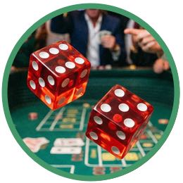 Närbild på två tärningar i luften ovanför ett spelbord på ett casino